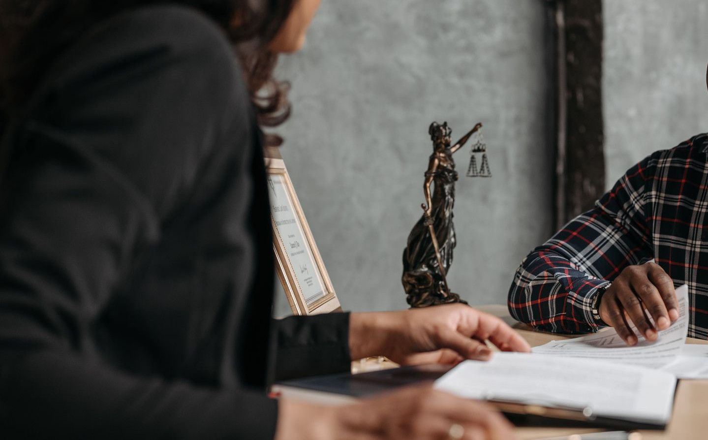 Business meeting between a lawyer and client in a professional office setting.
